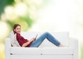 Teenage girl sitting on sofa with tablet pc Royalty Free Stock Photo