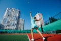 Young girl training on a new tennis court, throwing ball up and serving Royalty Free Stock Photo