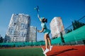 Jumping teenage girl training on a tennis court, throwing ball up and serving Royalty Free Stock Photo