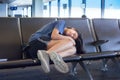 Teenage girl sleeping on airport bench in terminal, tired