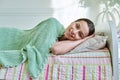 Teenage girl sleeping at home in bed, calm teenager looking at camera Royalty Free Stock Photo