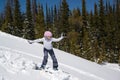 Teenage girl snowboarding down snowy hill in the mountains Royalty Free Stock Photo