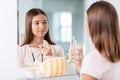 teenage girl spraying perfume at bathroom