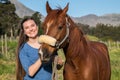 Teenage girl standing with her chestnut Arab horse looking at the camera Royalty Free Stock Photo