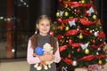 Teenage girl standing near the elegant Christmas tree with gifts