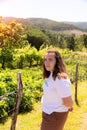 Teenage girl standing next to an orchard in the middle of a meadow and mountains Royalty Free Stock Photo