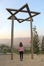 A teenage girl stands under star of David