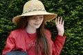 Teenage girl with straw hat says goodbye