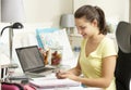 Teenage Girl Studying At Desk In Bedroom Using Mobile Phone Royalty Free Stock Photo