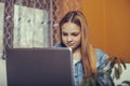 Teenage girl studying on her laptop, preparing for an exam while sitting on the couch at home Royalty Free Stock Photo