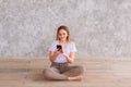 Teenage girl studying with her smartphone at home during quarantine isolation during coronavirus pandemic