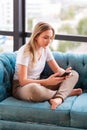 Teenage girl studying with her smartphone at home during quarantine isolation during coronavirus pandemic