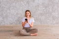 Teenage girl studying with her smartphone at home during quarantine isolation during coronavirus pandemic