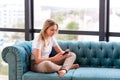 Teenage girl studying with her smartphone at home during quarantine isolation during coronavirus pandemic