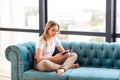 Teenage girl studying with her smartphone at home during quarantine isolation during coronavirus pandemic