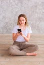 Teenage girl studying with her smartphone at home during quarantine isolation during coronavirus pandemic