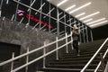 Teenage girl on subway stairs, with interior lights reflecting and Belgrade department store sign the night