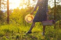 A teenage girl at sunset in a forest field holds a basket with lupines flowers and a straw hat. Impudence and femininity