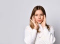 Teenage girl in sweater, smart watch and bracelet. She is looking at you, touching her face, posing isolated on white. Close up Royalty Free Stock Photo
