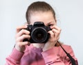 Teenage girl taking picture with DSLR camera, front view during shooting, grey background Royalty Free Stock Photo