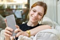 Teenage girl taking a selfie with a smart phone smiling sitting at home Royalty Free Stock Photo