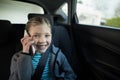 Teenage girl talking on mobile phone in the back seat of car Royalty Free Stock Photo