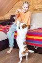 A teenage girl teaches commands to a small dog Jack Russell Terrier.