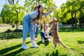 Teenage girl teasing her little dog while playing with it