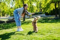 Teenage girl teasing her little dog while playing with it