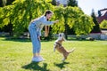 Teenage girl teasing her little dog while playing with it