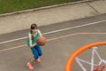 Teenage girl throwing a basketball at the net