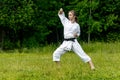 Teenage girl training karate kata outdoors, performs age-uke rising or upward block Royalty Free Stock Photo
