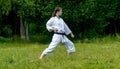 Teenage girl training karate kata outdoors, performs gedan-barai or downward block Royalty Free Stock Photo