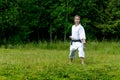 Teenage girl training karate kata outdoors, performs gedan-barai downward block Royalty Free Stock Photo