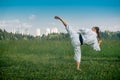 Teenage girl training karate kata outdoors, performs the uro mawashi geri hook kick Royalty Free Stock Photo