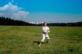 Teenage girl training karate kata outdoors, prepares to perform downward block gedan barai in zenkutsu dachi stance Royalty Free Stock Photo