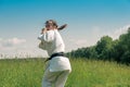 Teenage girl training karate kata outdoors, prepares to uro mawashi geri hook kick Royalty Free Stock Photo