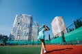 Teenage girl training on a new tennis court under a beautiful clear blue sky Royalty Free Stock Photo