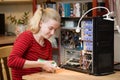 Teenage girl using a can of compressed air to clean the inside of a PC Royalty Free Stock Photo