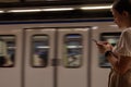 teenage girl using cell phone while passing subway or subway train with copy space Royalty Free Stock Photo