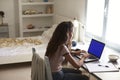 Teenage girl using laptop computer at a desk in her bedroom Royalty Free Stock Photo