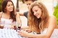 Teenage Girl Using Mobile Phone Sitting At CafÃ¯Â¿Â½ With Friends Royalty Free Stock Photo