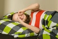 Teenage girl wakes up, rubs eyes. Lying on a pillow in bed, top view Royalty Free Stock Photo