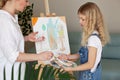 Teenage girl was upset and unhappy that she got her hands dirty in paint while painting picture for art lesson