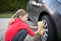 Teenage girl washing a car on a sunny day Royalty Free Stock Photo