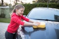 Teenage girl washing a car on a sunny day Royalty Free Stock Photo