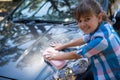 Teenage girl washing a car on a sunny day Royalty Free Stock Photo