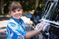 Teenage girl washing a car on a sunny day Royalty Free Stock Photo