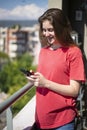 Teenage Girl Watching Her Mobile Phone and Smiling When She is Texting Royalty Free Stock Photo