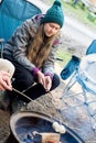 Teenage girl wearing beanie hat roasting large marshmallow on a stick over the campfire firepit. Camping family fun Royalty Free Stock Photo